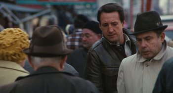 Movie still from “The Seven-Ups” (1973), directed by Philip D'Antoni – A group of people that are standing in the street; Close Up shot, Over the shoulder angle