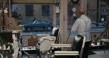 Movie still from “The Seven-Ups” (1973), directed by Philip D'Antoni – A man standing in front of a shop window; Wide shot, Over the shoulder angle