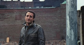 Movie still from “The Seven-Ups” (1973), directed by Philip D'Antoni – A man standing in front of a brick wall; Close Up shot, Over the shoulder angle