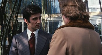 Movie still from “The Seven-Ups” (1973), directed by Philip D'Antoni – A man wearing a suit and tie talking to a woman wearing a coat; Medium shot, Over the shoulder angle