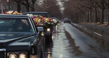 Movie still from “The Seven-Ups” (1973), directed by Philip D'Antoni – A bunch of flowers are in the back of a car; Wide shot, Over the shoulder angle