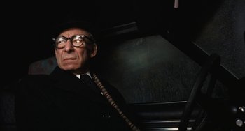 Movie still from “The Seven-Ups” (1973), directed by Philip D'Antoni – An old man wearing glasses and a black hat; Close Up shot, Low angle