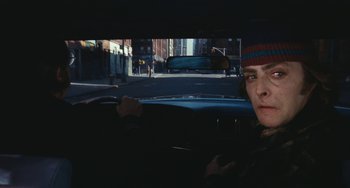 Movie still from “The Seven-Ups” (1973), directed by Philip D'Antoni – A man driving a car on a street; Close Up shot, Over the shoulder angle