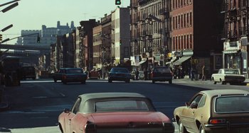 Movie still from “The Seven-Ups” (1973), directed by Philip D'Antoni – Cars are driving down a busy street in a city; Wide shot, Over the shoulder angle