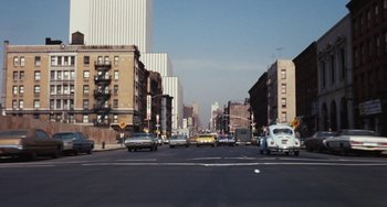 Movie still from “The Seven-Ups” (1973), directed by Philip D'Antoni – A city street filled with lots of traffic and buildings; Extreme Wide shot, High angle