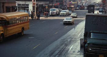 Movie still from “The Seven-Ups” (1973), directed by Philip D'Antoni – Cars are driving down the street in a busy city; Extreme Wide shot, High angle