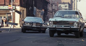 Movie still from “The Seven-Ups” (1973), directed by Philip D'Antoni – A couple of cars that are on the street; Wide shot, Low angle
