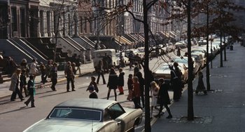 Movie still from “The Seven-Ups” (1973), directed by Philip D'Antoni – A group of people walking down a street next to cars; Extreme Wide shot, High angle