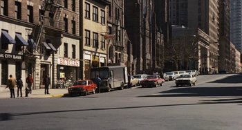 Movie still from “The Seven-Ups” (1973), directed by Philip D'Antoni – A street scene with a van parked on the side of the road; Extreme Wide shot, High angle