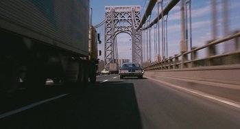 Movie still from “The Seven-Ups” (1973), directed by Philip D'Antoni – Cars driving on a road under a bridge; Extreme Wide shot, High angle