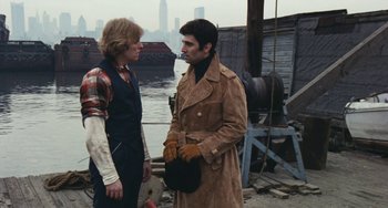 Movie still from “The Seven-Ups” (1973), directed by Philip D'Antoni – Two men standing next to each other near a body of water; Medium shot, Over the shoulder angle