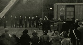 Movie still from “The Ship Sails On” (1983), directed by Federico Fellini – A group of people standing in front of a crowd; Wide shot, Over the shoulder angle