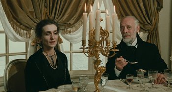 Movie still from “The Ship Sails On” (1983), directed by Federico Fellini – A man and a woman sitting at a dinner table; Medium shot, High angle