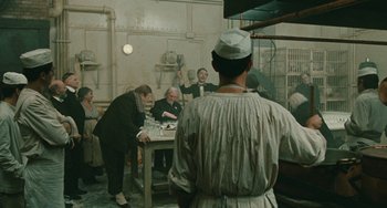 Movie still from “The Ship Sails On” (1983), directed by Federico Fellini – A group of people sitting around a table; Wide shot, High angle