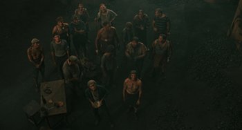 Movie still from “The Ship Sails On” (1983), directed by Federico Fellini – A group of men standing in a dark room; Wide shot, High angle