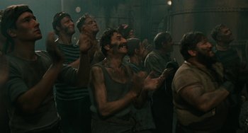 Movie still from “The Ship Sails On” (1983), directed by Federico Fellini – A group of men standing next to each other in a room; Medium shot, High angle