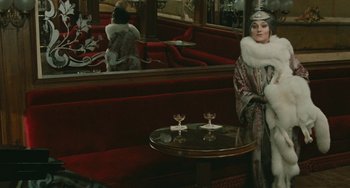 Movie still from “The Ship Sails On” (1983), directed by Federico Fellini – A woman standing in front of a mirror in a living room; Medium shot, Over the shoulder angle