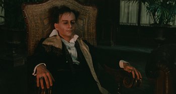 Movie still from “The Ship Sails On” (1983), directed by Federico Fellini – A man sitting in a chair with his eyes closed; Medium shot, High angle