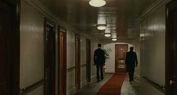 Movie still from “The Ship Sails On” (1983), directed by Federico Fellini – Two men are walking down the hall of a hotel; Wide shot, Low angle