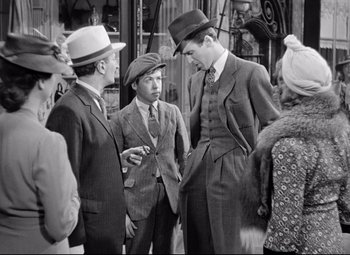 Movie still from “The Shop Around the Corner” (1940), directed by Ernst Lubitsch – A group of men standing next to each other on the street; Medium shot, Over the shoulder angle