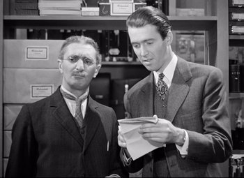 Movie still from “The Shop Around the Corner” (1940), directed by Ernst Lubitsch – Two men standing next to each other holding papers; Medium shot, Over the shoulder angle