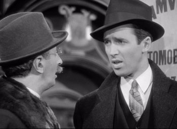 Movie still from “The Shop Around the Corner” (1940), directed by Ernst Lubitsch – A man in a hat and a man in a suit and tie; Close Up shot, Over the shoulder angle