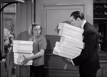 Movie still from “The Shop Around the Corner” (1940), directed by Ernst Lubitsch – A man and a woman holding boxes of pizza; Medium shot, High angle