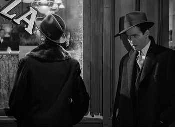 Movie still from “The Shop Around the Corner” (1940), directed by Ernst Lubitsch – A man and a woman wearing hats looking at each other; Medium shot, Over the shoulder angle