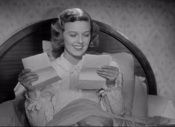 Movie still from “The Shop Around the Corner” (1940), directed by Ernst Lubitsch – A black and white photo of a woman holding a box; Medium shot, Low angle