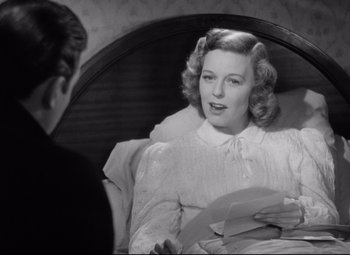 Movie still from “The Shop Around the Corner” (1940), directed by Ernst Lubitsch – A black and white photo of a woman in a white dress; Medium shot, Over the shoulder angle