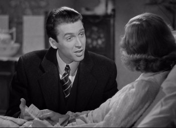 Movie still from “The Shop Around the Corner” (1940), directed by Ernst Lubitsch – A man in a suit and tie talking to a woman; Close Up shot, Over the shoulder angle