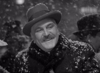 Movie still from “The Shop Around the Corner” (1940), directed by Ernst Lubitsch – A black and white photo of a man in a hat and scarf; Close Up shot, Low angle