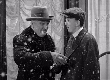 Movie still from “The Shop Around the Corner” (1940), directed by Ernst Lubitsch – Two men shaking hands in the snow; Medium shot, High angle