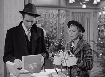Movie still from “The Shop Around the Corner” (1940), directed by Ernst Lubitsch – A man and a woman looking at something on a table; Medium shot, High angle
