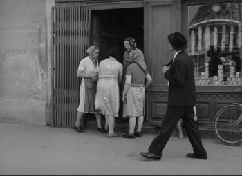 Movie still from “The Shop on Main Street” (1965), directed by Ján Kadár – A black and white photo of a group of people standing in front of a building; Wide shot, Low angle