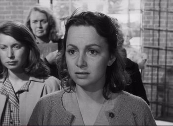 Movie still from “The Snake Pit” (1948), directed by Anatole Litvak – An old black and white photo of a woman in front of other women; Close Up shot, Over the shoulder angle