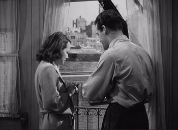 Movie still from “The Snake Pit” (1948), directed by Anatole Litvak – A man and a woman standing next to each other near a window; Medium shot, High angle