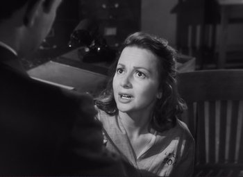 Movie still from “The Snake Pit” (1948), directed by Anatole Litvak – A woman sitting in a chair looking up at something; Close Up shot, Over the shoulder angle