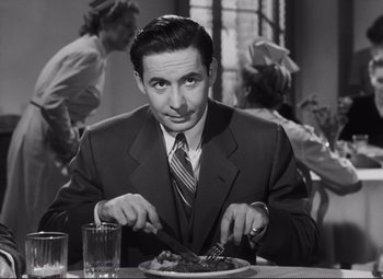Movie still from “The Snake Pit” (1948), directed by Anatole Litvak – A black and white photo of a man eating a plate of food; Medium shot, High angle
