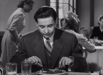 Movie still from “The Snake Pit” (1948), directed by Anatole Litvak – A black and white photo of a man eating a plate of food; Medium shot, High angle