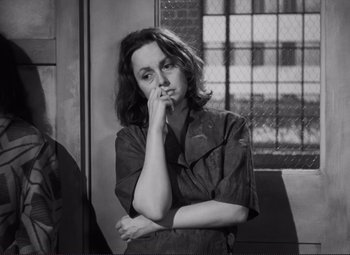 Movie still from “The Snake Pit” (1948), directed by Anatole Litvak – Black and white photograph of a woman leaning against a wall; Close Up shot, High angle
