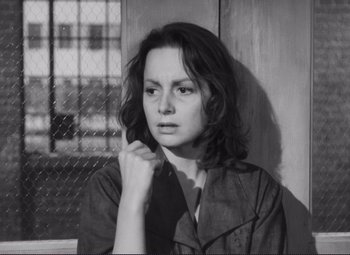 Movie still from “The Snake Pit” (1948), directed by Anatole Litvak – Black and white photograph of a young woman in front of a fence; Close Up shot, High angle