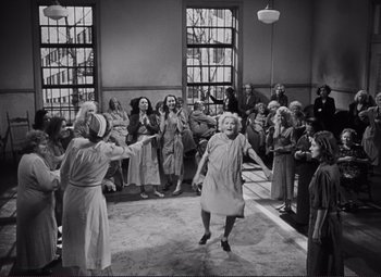 Movie still from “The Snake Pit” (1948), directed by Anatole Litvak – An old photo of a group of people dancing; Wide shot, High angle