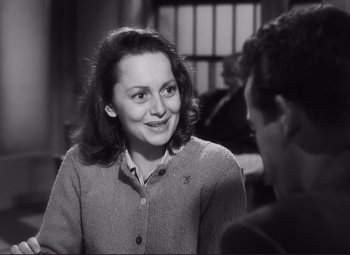 Movie still from “The Snake Pit” (1948), directed by Anatole Litvak – A woman smiles while talking to a man in front of a window; Close Up shot, Over the shoulder angle