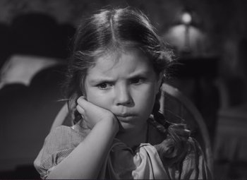 Movie still from “The Snake Pit” (1948), directed by Anatole Litvak – A little girl sitting in a chair with her chin resting on her hand; Close Up shot, High angle