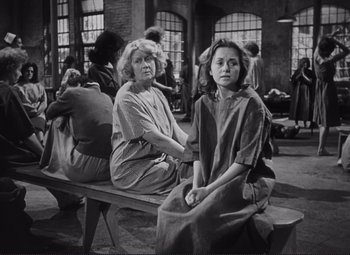 Movie still from “The Snake Pit” (1948), directed by Anatole Litvak – Two women sitting on a bench in a room; Medium shot, High angle