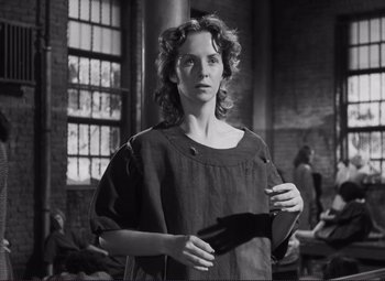 Movie still from “The Snake Pit” (1948), directed by Anatole Litvak – A young woman holding an object in her hands; Medium shot, Low angle