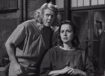 Movie still from “The Snake Pit” (1948), directed by Anatole Litvak – Two women standing next to each other in front of a brick building; Medium shot, Low angle
