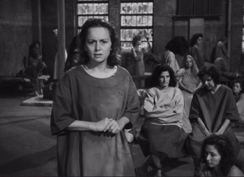 Movie still from “The Snake Pit” (1948), directed by Anatole Litvak – Black and white photograph of a woman in front of a group of people; Medium shot, High angle
