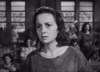 Movie still from “The Snake Pit” (1948), directed by Anatole Litvak – Black and white photograph of a young woman in front of a group of people; Close Up shot, High angle